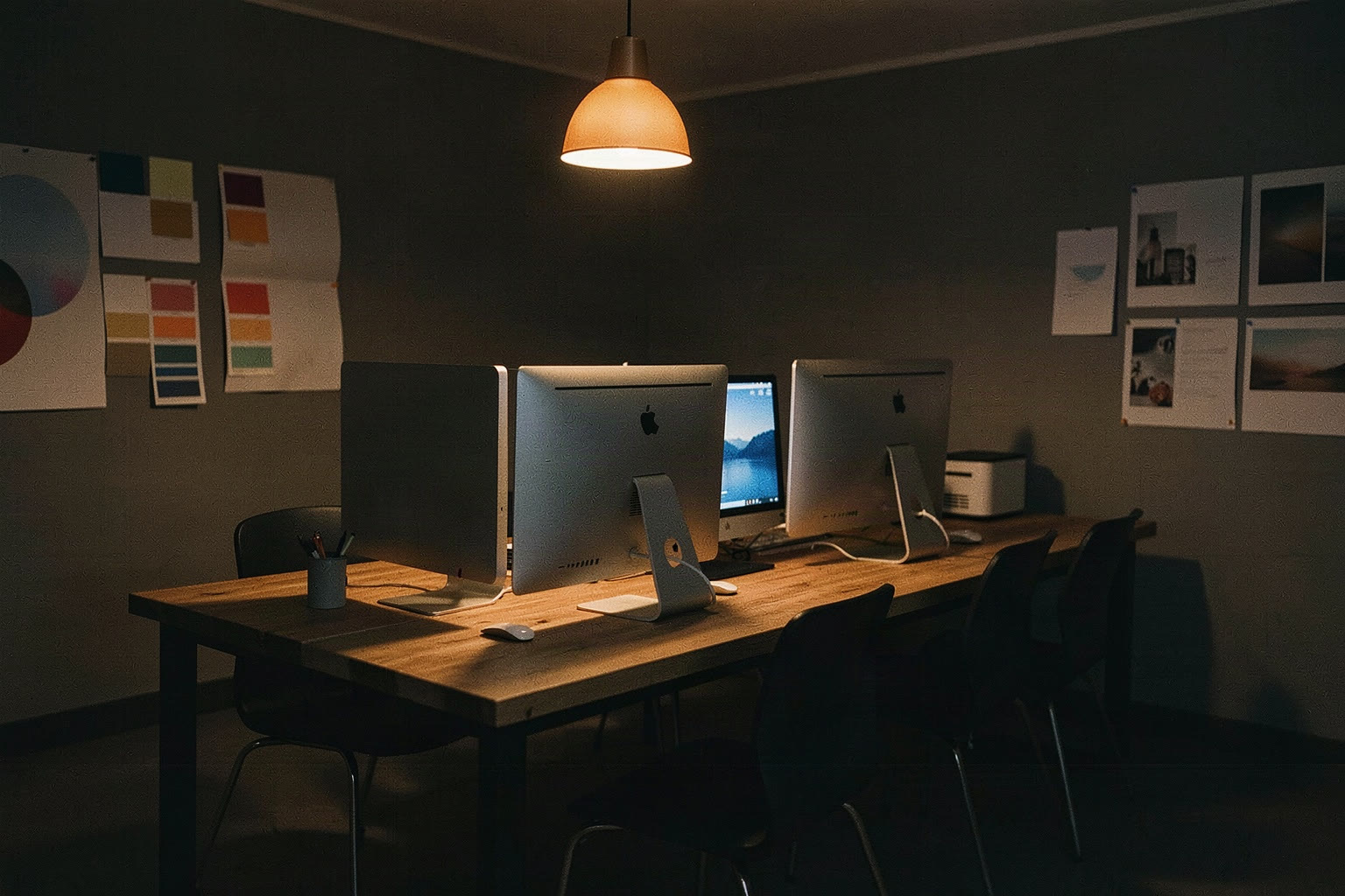 Büro am Abend, leere Schreibtische unter einer warmen Lampe